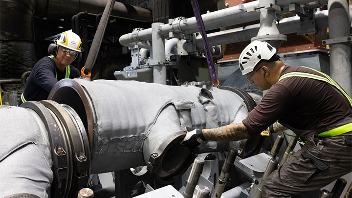 two people working on the assembly of an engine