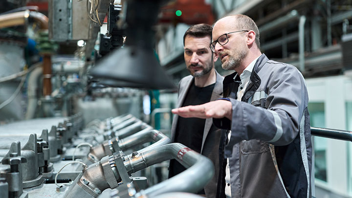 Matthias Auer, Head of Performance and Emissions, MAN Energy Solutions Matthias Auer explaining the methanol engine to a colleague